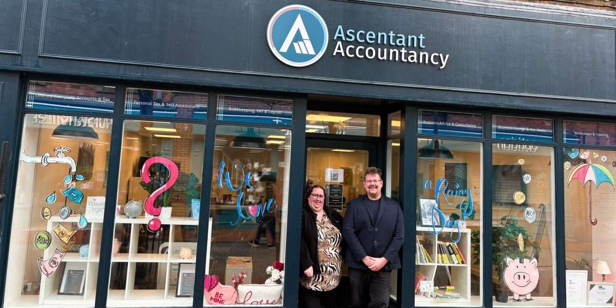 Kevin and Kim in the doorway of our Ripley office with beautifully illustrated monopoly themed windows.