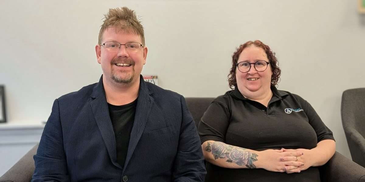 PXL_20260209_120119923~2 Kevin and Kim sat on the sofa in the Ascentant office smiling at the camera