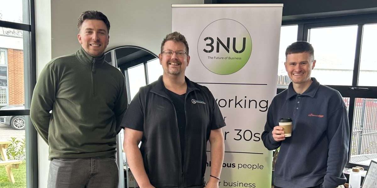 Image Kevin Drew with William and Jack from 3NU at the networking event. They're all smiling and looking at the camera in front of a 3NU banner.