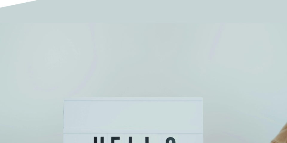 Photo of a person holding a sign saying 'HELLO' with the Ascentant logo