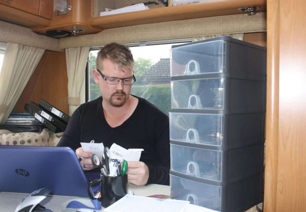 Kevin in a caravan with his laptop working hard