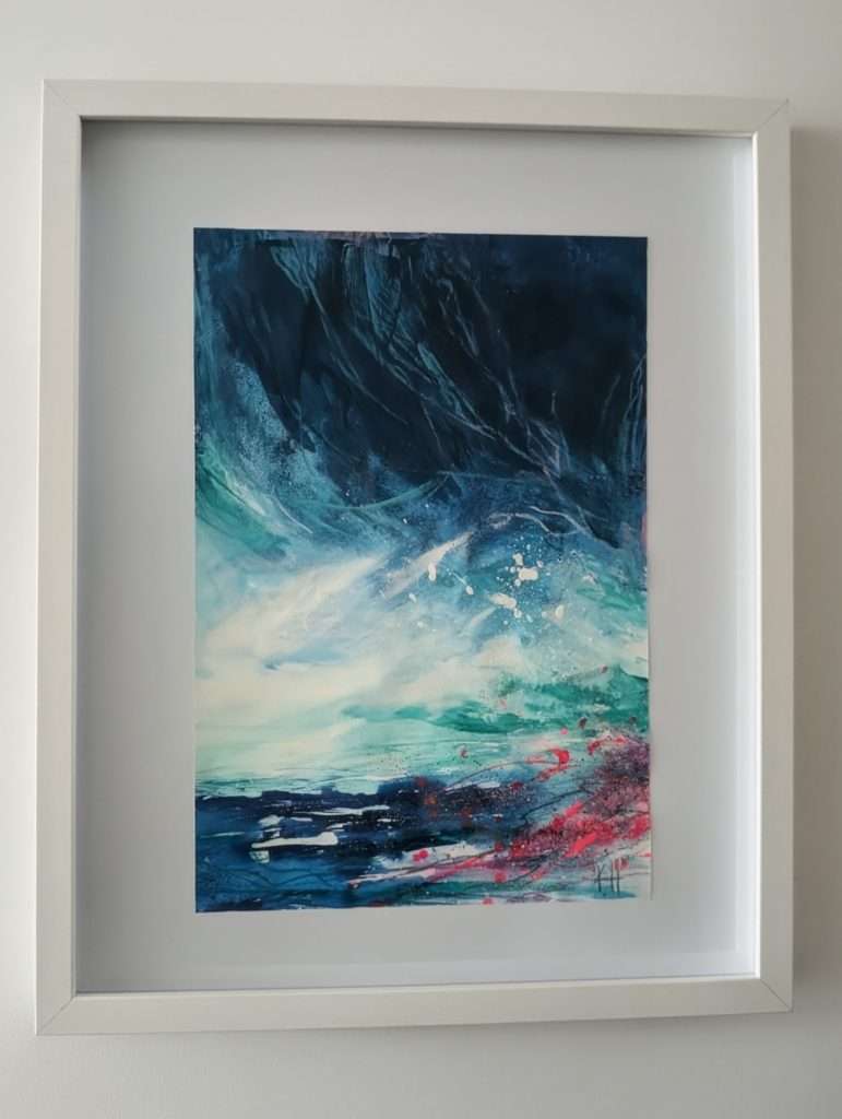 A photo of Kelly's artwork which features an abstract scene of blues and a splash of pink.
