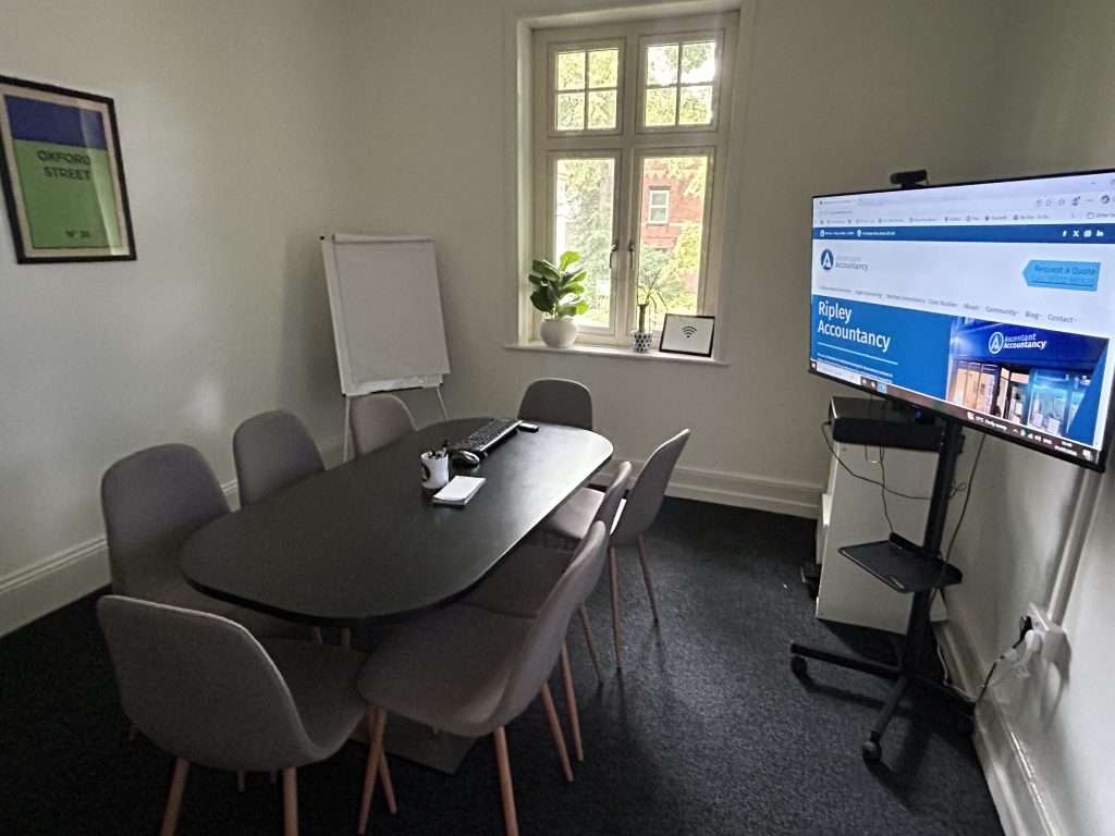 Our meeting room with a large table, eight chairs, screen and flipchart. 